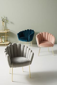 three different colored chairs in a room