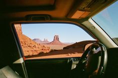 the interior of a car with mountains in the background