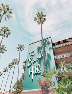 the beverly hotel sign is surrounded by palm trees