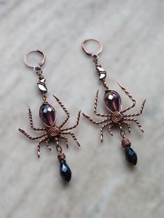 creepy, fancy spider earrings for the witch or lover of halloween season and creepy crawlies in your life!  made with solid, twisty antiqued copper wire, a faceted purple glass teardrop bead for the body, faceted dark navy blue glass briolettes hanging below  & lil hematite moons connecting the spiders to the hook✨ spider width is about 1.35" at widest part, drop length is about 2.5" and these are very lightweight for their size!  choose your hypoallergenic hooks :) Witchy Halloween Earrings, Witchy Halloween Party Earrings, Mystical Handmade Earrings For Party, Handmade Mystical Earrings For Party, Witchy Drop Earrings, Handmade Witchy Earrings For Halloween, Handmade Vampire Jewelry For Halloween, Handmade Black Fantasy Earrings, Halloween Vampire Metal Earrings