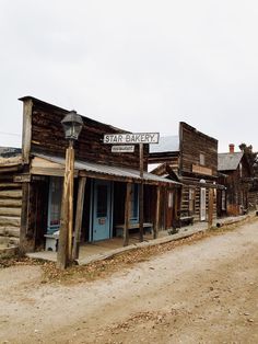 an old western town with wooden buildings and signs on the side of the road that says star bakery