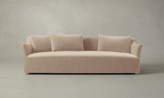 a beige couch with four pillows on it