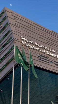 two flags are flying in front of a building