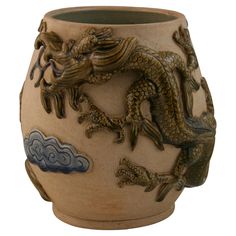 a vase with a dragon design on the side and clouds in the sky behind it