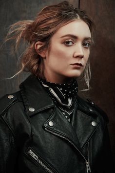 a woman wearing a black leather jacket and bandana