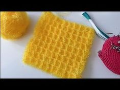 two crocheted items sitting on top of a white table next to a ball of yarn