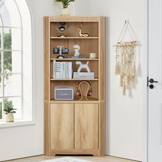 a wooden bookcase sitting in front of a window next to a rug and potted plant