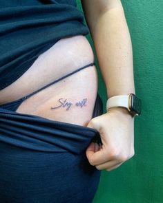 a pregnant woman's belly with the word stay wild written on her lower side