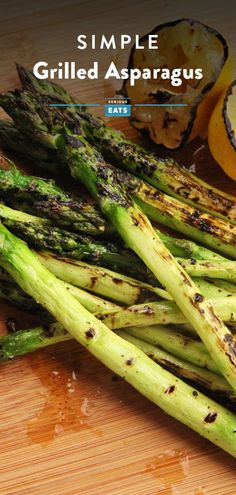 grilled asparagus on a cutting board with lemons