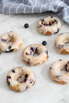 blueberry donuts with icing on a baking sheet