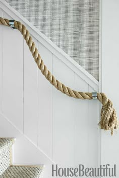 a rope hanging on the side of a stair case next to a handrail in a house beautiful