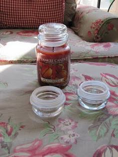 a jar of candles sitting on top of a table next to two empty glass jars