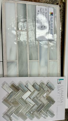 some glass tiles sitting on top of a counter next to a package of magnets