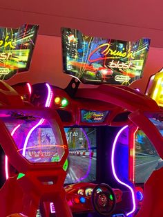 two video game machines with neon lights on the sides and one has a steering wheel