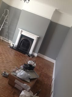 a living room with hard wood flooring and a fire place in the middle of it