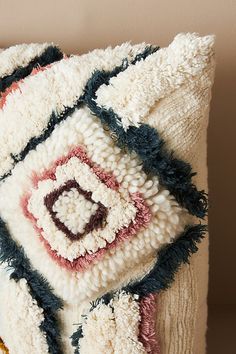 a decorative pillow with an abstract design on the front and back sides, sitting on a table