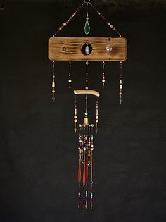 a wind chime hanging from the side of a black wall with beads on it