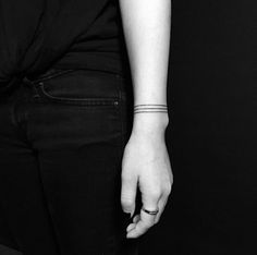 black and white photograph of a woman's arm with a small tattoo on it