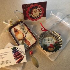 two christmas ornaments are sitting on the counter next to a card and some other items