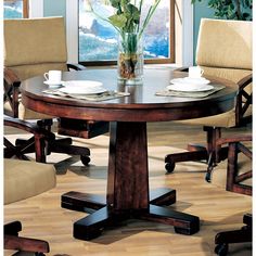 a dining room table with chairs around it and a vase full of flowers on the table