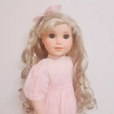 a doll with blonde hair wearing a pink dress