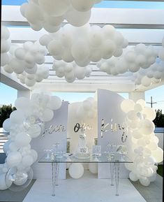 an outdoor event with white balloons and clear tables