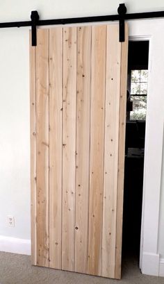 the sliding door is made from wood and has black hardware on it's sides