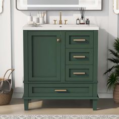 a bathroom vanity with green cabinet and white counter top, next to potted plant