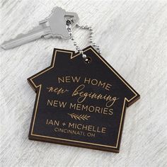 a house shaped keychain with the words new home, beginning new memories written on it