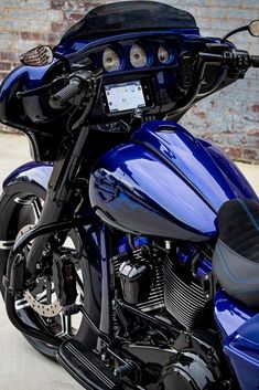 a blue motorcycle parked next to a brick wall