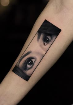 a woman's arm with an eye tattoo on the upper half of her arm