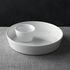 a white plate with two cups on it and a gray place mat in the background