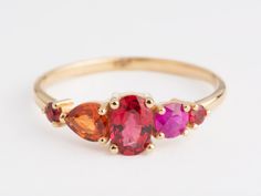 A beautiful handmade engagement ring. This one of a kind cluster ring consists of a large 0.50 ct oval cut red sapphire which is surrounded by 1 pear cut orange sapphire, 1 round brilliant cut Magenta Ruby and 2 small red Sapphires weighing a total of 1.15 ct. This ring is available in 14k rose/yellow/white gold. Ring features: fineness: 14K White/Yellow/Rose Gold stone type: Sapphire cut: Oval, Pear, Round  quantity of stones: 5 Sapphire: 1.15 ct Delivery time: 7-14 business days Production sta Red Sapphire Ring, Engagement Ring Cluster, Handmade Engagement Ring, Cut Orange, Ring Cluster, Red Sapphire, Handmade Engagement Rings, Orange Sapphire, Sapphire Engagement Ring