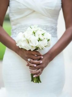 a woman holding a bouquet of white flowers