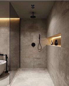 a bathroom with a tub, shower head and lights on the side of the wall