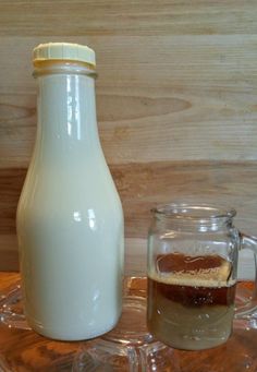 a bottle of milk next to a glass mug on a table