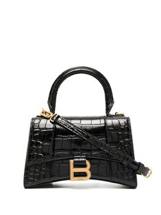 Black leather Hourglass top-handle tote bag from Balenciaga featuring crocodile effect, gold-tone logo plaque, single rounded top handle, adjustable detachable shoulder strap, foldover top with magnetic fastening, main compartment, internal logo stamp and internal zip pocket. | Balenciaga Hourglass top-handle tote bag Sacs Tote Bags, Luxury Purses, Balenciaga Bag, Black Leather Handbags, Black Shoulder Bag, Logo Stamp, Black Tote Bag, Black Handbags, Womens Tote Bags