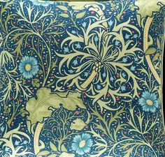 an intricately designed pillow with blue flowers and leaves on it's back side