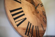 a large wooden clock with roman numerals on it's face and hands