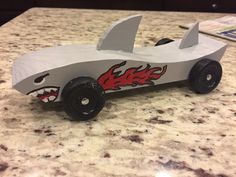 a paper model of a car with shark teeth on it's side sitting on a counter top