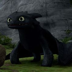 an animated black dragon with big eyes sitting next to a giant ball in the grass