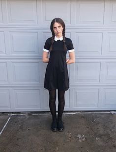 a young woman standing in front of a garage door with her hands on her hips