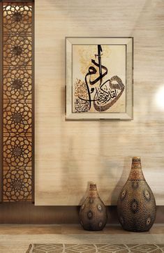 two vases sitting on a table in front of a wall with arabic calligraphy