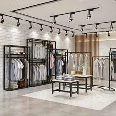 an empty clothing store with clothes hanging on racks and tables in front of the display