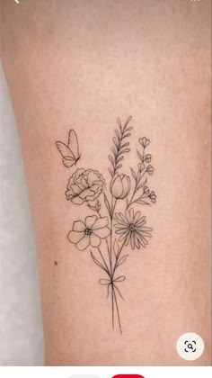 a small flower tattoo on the back of a woman's leg