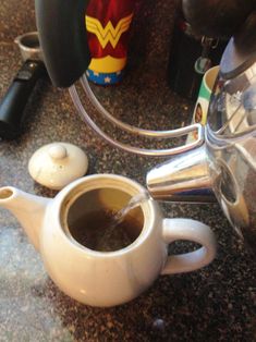 a cup of coffee sitting on top of a counter next to a blender and other items