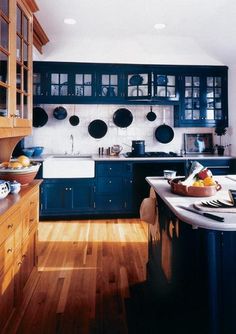 a kitchen with blue cabinets and wooden floors