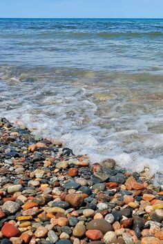 there are rocks on the beach next to the water