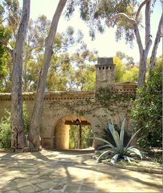 an old stone building surrounded by trees and bushes