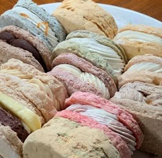 a white plate topped with lots of different types of cookies and doughnuts on top of each other